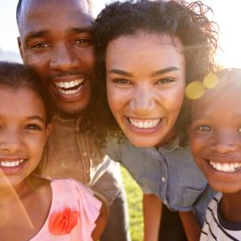 laughing-black-family-outdoors-close-up-back-lit-PPCMZD4.jpg